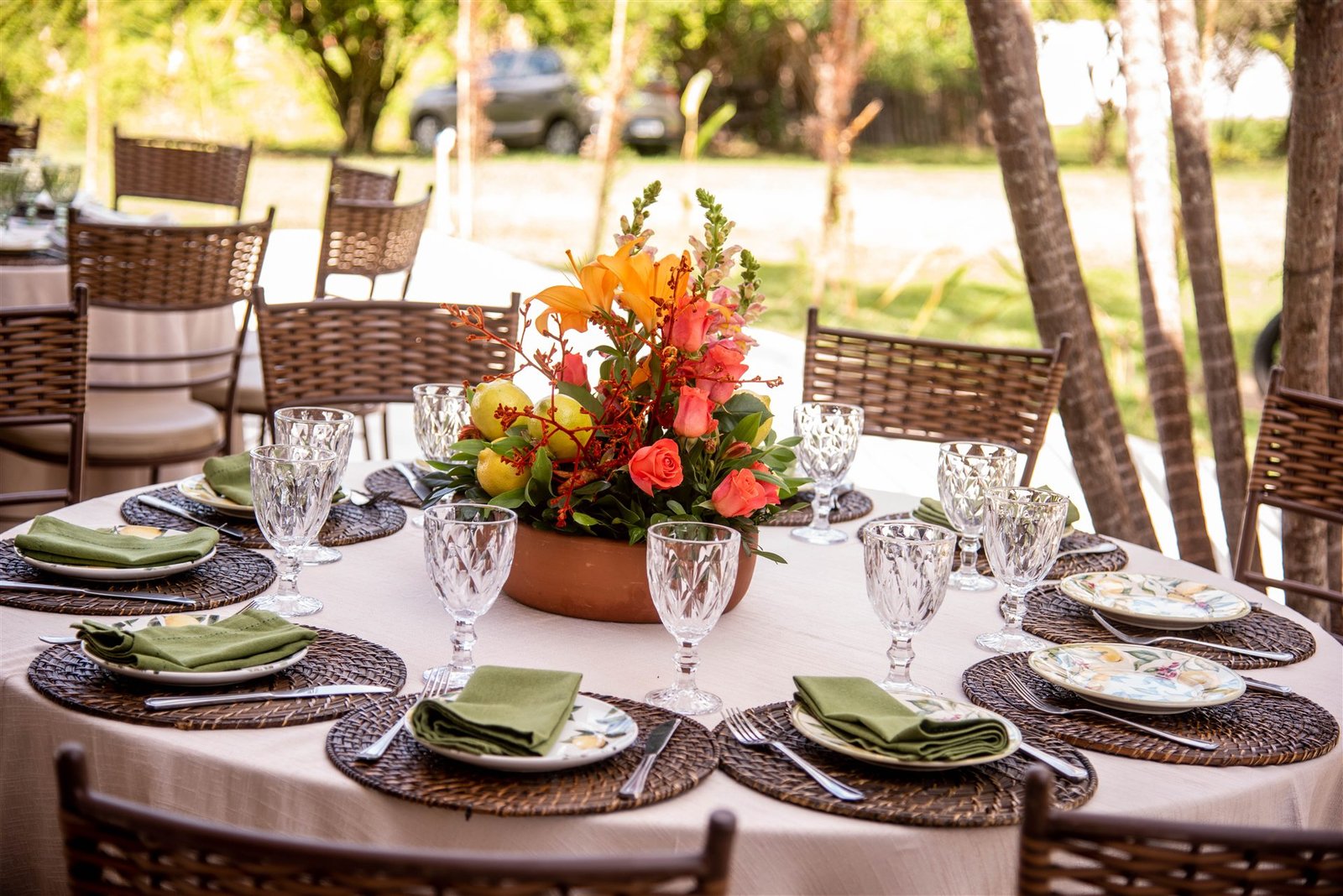 Mesa posta com louças e arranjo floral em tons quentes